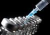 Lineaup of vaccine vials with syringe