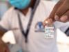 Man holding COVID vaccine vial