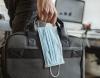 Man carrying briefcase and surgical mask