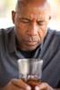 Man with drink looking troubled