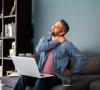 Man at laptop experiencing neck, shoulder pain