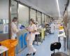 Mask-wearing health workers in hospital hallway
