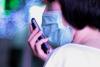 Woman with cell phone and surgical mask