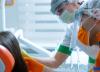 Masked dental workers with patient
