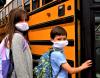 Masked kids boarding school bus