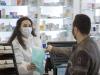 Masked pharmacist dispensing drugs
