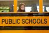 Masked schoolgirl looks out bus window