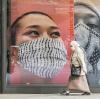 Masked woman walking in front of masking signs