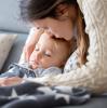 Mom kissing sick boy on forehead