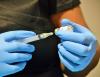 Needle going into COVID vaccine vial