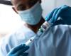 Healthcare worker drawing vaccine from vial