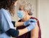 Nurse giving elderly woman vaccine