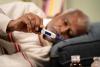 Older man lying down checking his temperature