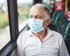 Older man wearing mask on bus