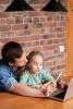 Daughter doing online learning with dad