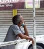 Pensive man outside with mask on chin