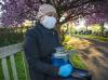 Woman wearing mask and holding urn in cemetary