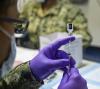 Pfizer COVID vaccine vial drawing into syringe