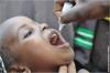 An African child is given a dose of oral polio vaccine.
