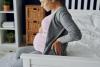 Pregnant woman sitting on bed