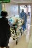 Nurses pushing gurney in hospital hallway