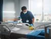 Hospital worker sanitizing hospital bed