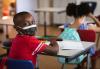 Young student wearing mask at desk