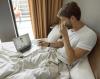 Sick man in bed telehealth consult
