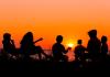 Teens at camp at sunset in silhouette