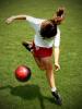 Girl kicking soccer ball overhead view