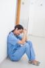 Stressed-out nurse sitting on floor