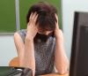 Stressed teacher wearing mask at her desk