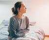 Suffering woman sitting on bed
