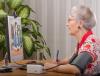 Older woman telemedicine wearing blood pressure cuff