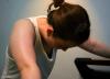 Tired woman leaning on treadmill