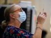 Vaccinator holding up syringe