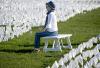 Woman sitting among white COVID flags
