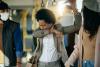 Woman coughing into sleeve on train