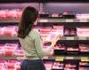 Woman in grocery store meat aisle
