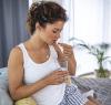 Woman on couch taking pill