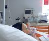 Woman in hospital bed wearing oxygen mask