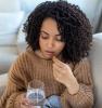Woman taking drug capsule