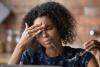 Woman with headache at laptop
