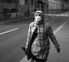 Lone woman with mask walking along street