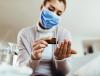 Woman with mask taking pills