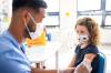 Young girl getting vaccinated, wearing mask