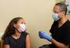 Young girl in mask getting vaccinated